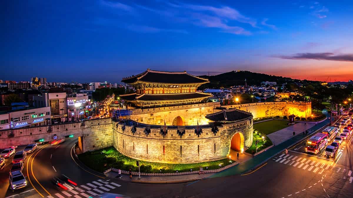 Hwaseong Fortress in Suwon showing UNESCO World Heritage stone fortress wall winding through modern city, Joseon Dynasty architectural masterpiece